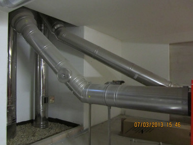 Gray PVC pipes and HVAC ducts run across a basement ceiling.